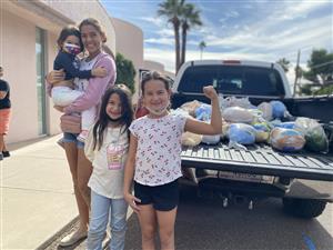 Children posing in front of the donated turkeys for Thanksgiving.