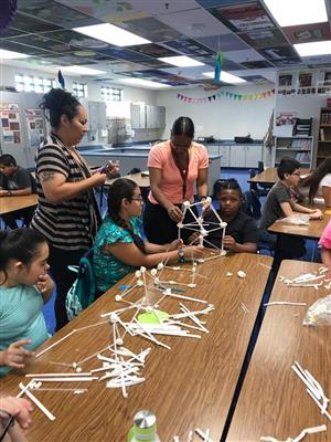 Students work together to build tall towers. 