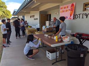 Parent volunteers, students, and staff set up for fall festival. 